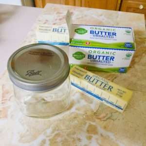A jar of butter next to some organic butter.